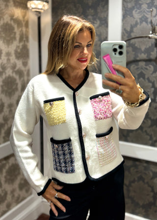 Add a playful twist to your outfit with this cream knit cardi, featuring multicoloured textured pockets with a bold black edge. The Pocketed Funky Cream Cardi brings a fun splash of colour and unique detail, perfect for brightening up any look with cheerful charm.
