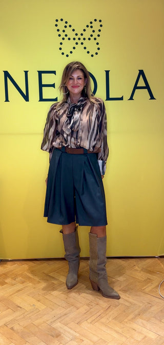 These tailored grey shorts feature two refined pleats on the front, adding structured elegance to a classic silhouette. Paired with a brown belt, they offer a polished and sophisticated look perfect for smart casual occasions. The elastic waist with structured knee-length design elevates your style with a timeless finish.