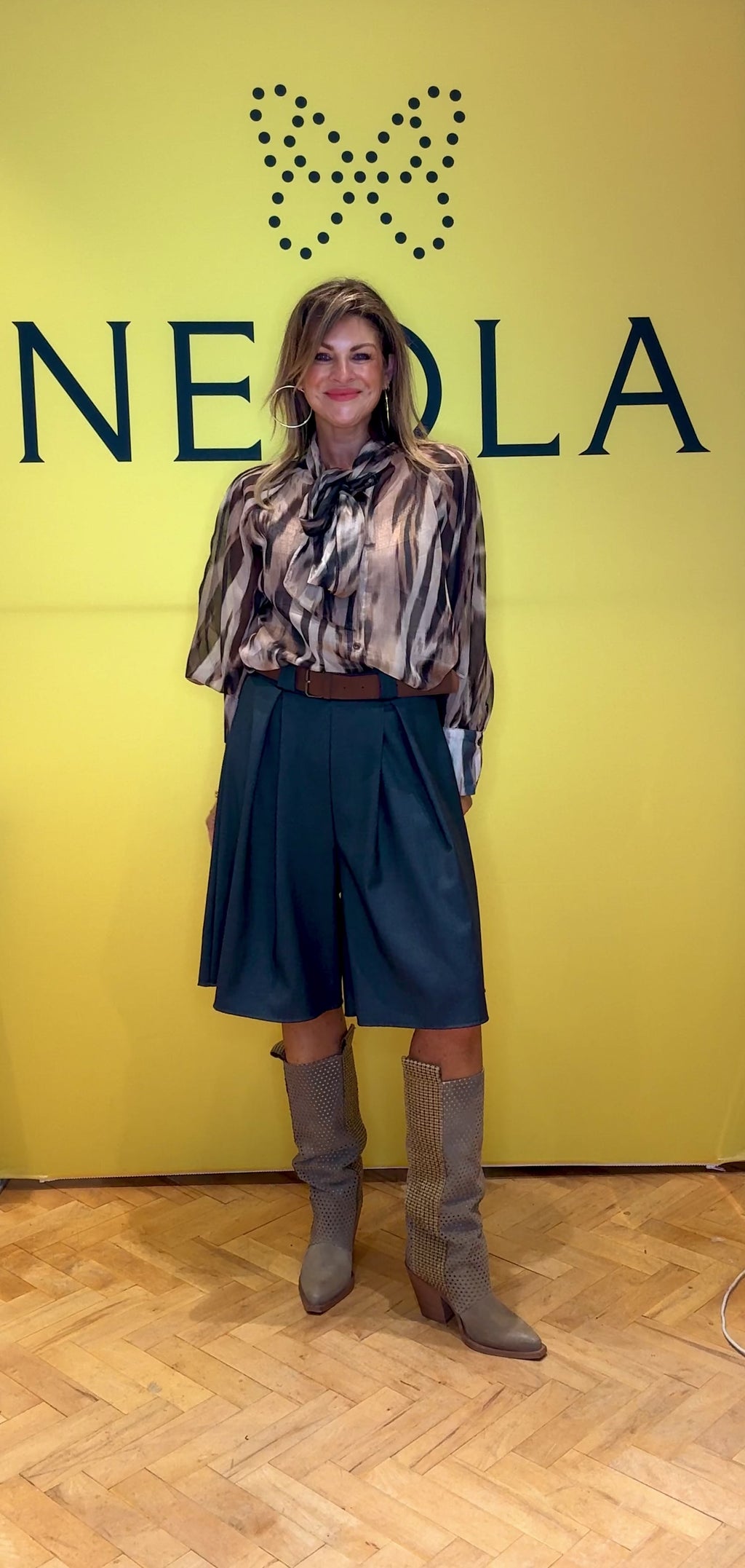 These tailored grey shorts feature two refined pleats on the front, adding structured elegance to a classic silhouette. Paired with a brown belt, they offer a polished and sophisticated look perfect for smart casual occasions. The elastic waist with structured knee-length design elevates your style with a timeless finish.