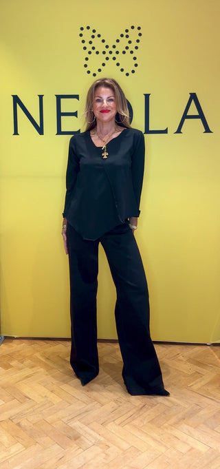 This black long sleeve top features stylish 3/4 length cuffed sleeves for a polished touch. The asymmetrical neckline and hem create a modern silhouette, while the stitch detail across the front adds unique character. Perfect for those who appreciate subtle, distinctive design that sets you apart effortlessly.