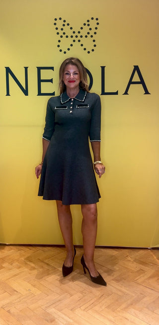 This grey knit dress features 3/4 length sleeves and a below knee length hem. A refined collared neckline clasped by glamorous buttons with elegant pearl details combine cozy comfort with timeless sophistication for a polished, feminine look. 